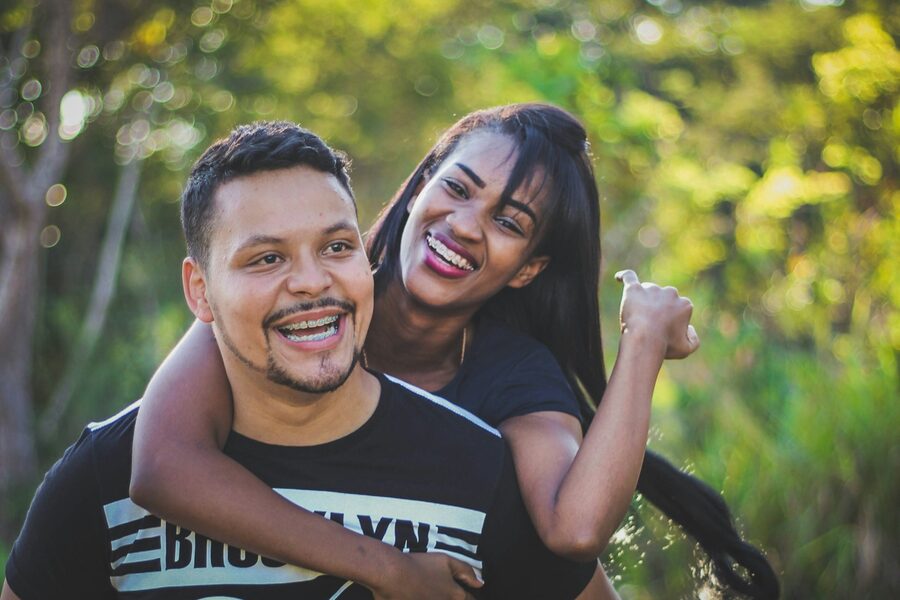 Casal jovem sorrindo ao ar livre, planejando o futuro