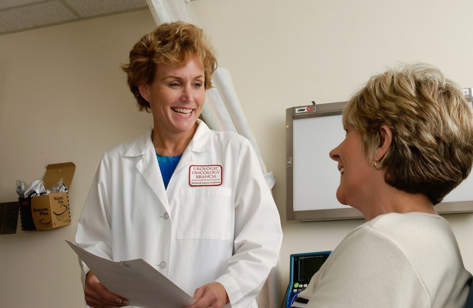 Médica conversando e sorrindo com uma paciente