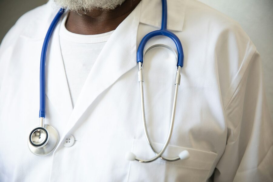 Médico com estetoscópio no pescoço em ambiente hospitalar